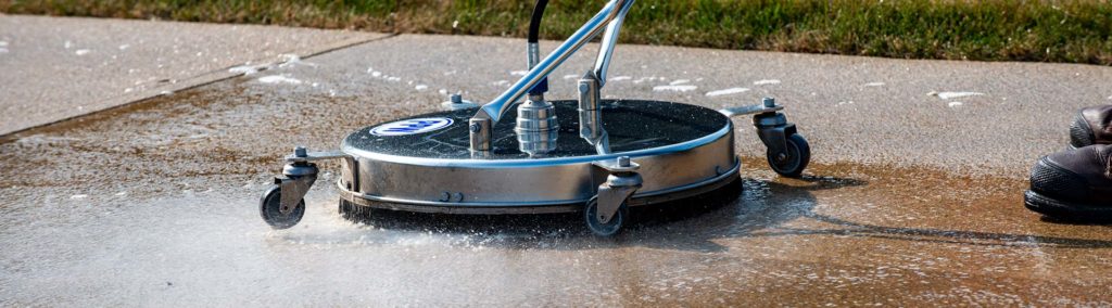 There are many reasons why pros should power wash your business. Here, a surface cleaner is being used to beautify and protect commercial concrete.