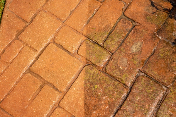 Side by side photo of freshly washed brick surface next to area that has not yet been washed