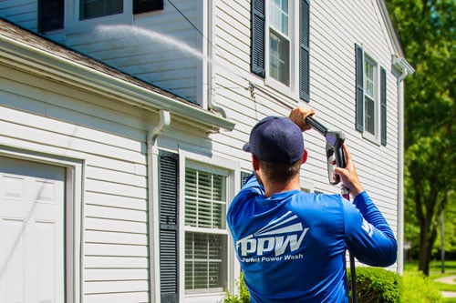How it works: Power washing technician washing vinyl siding with safe pressure
