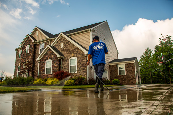 Perfect Power Wash technician sealing concrete, which is one of many offerings in our professional power washing services.