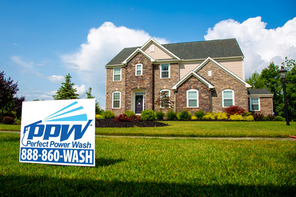 About us: Perfect Power Wash sign in yard of perfectly cleaned brick home