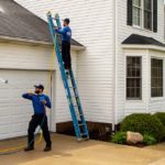 Professional power washing technicians working to improve curb appeal on a vinyl sided home.