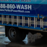 Perfect Power Wash employee washing concrete next to a company vehicle
