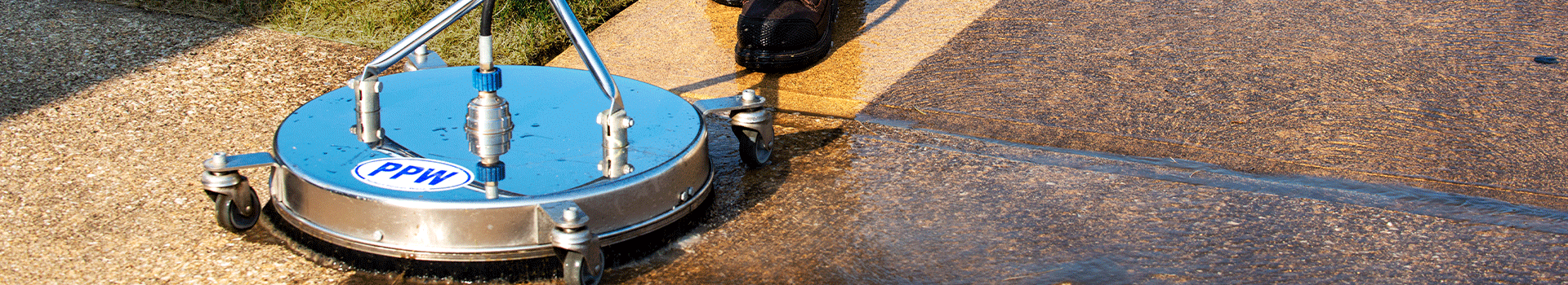 A surface cleaner with a PPW sticker cleaning a concrete driveway, showing a before and after effect