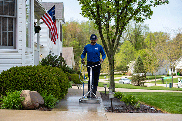 Perfect Power Wash employee surface cleaning a concrete walkway