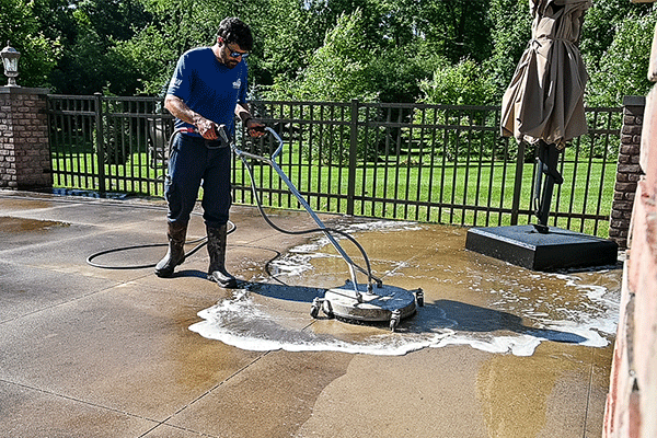 Perfect Power Wash technician surface cleaning a concrete patio